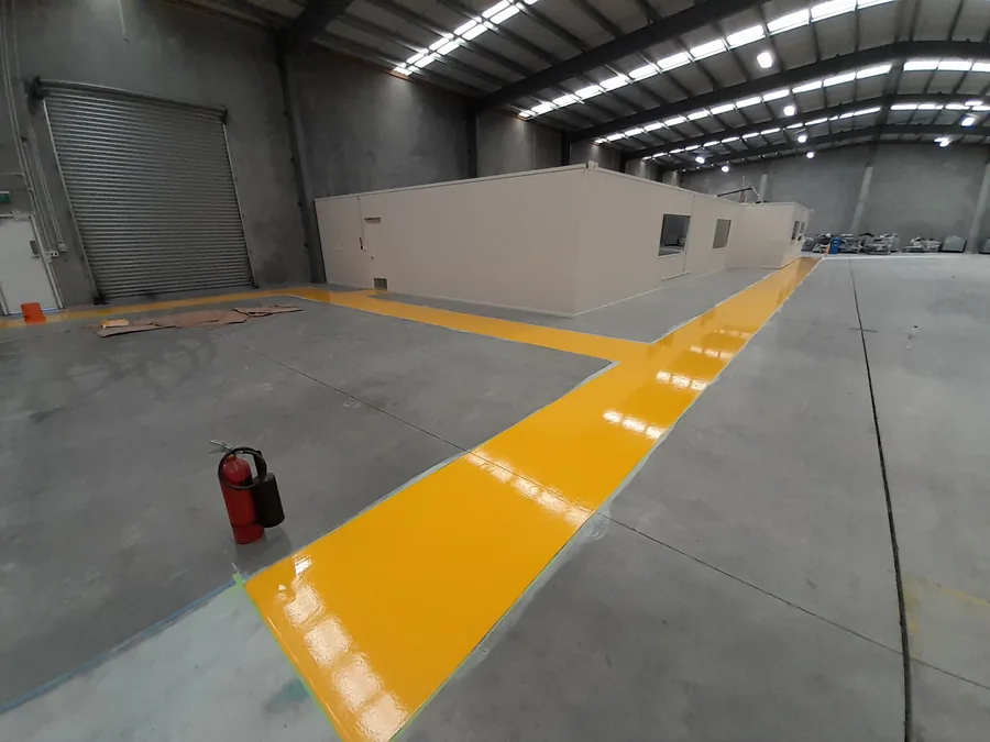 Yellow safety line marking on warehouse concrete floor